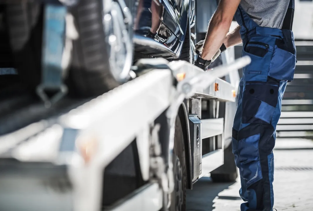 Minneapolis tow truck driver loading a car onto a flatbed